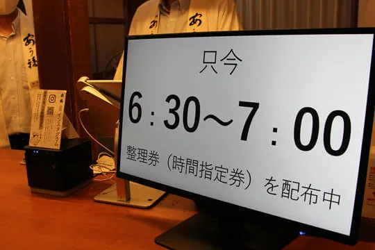 時間指定の整理券の配布を知らせる店頭の画面（赤福本店）