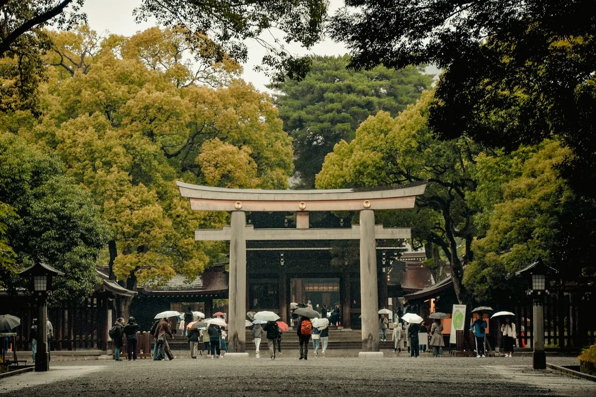 神社の鳥居の前を歩く参拝の人たち（イメージ）