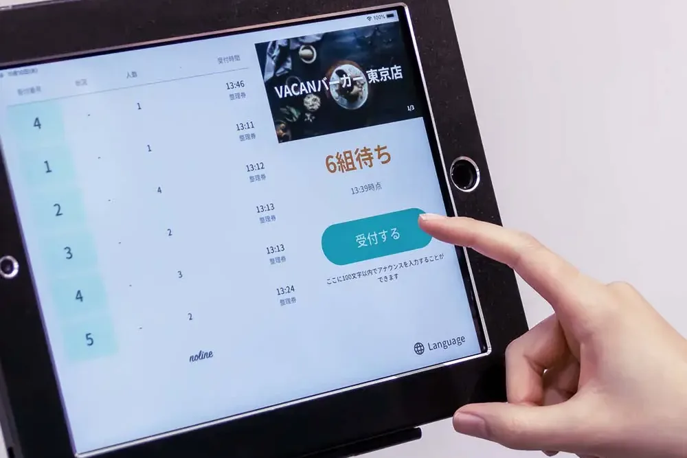 整理券を受け付けるタブレットを操作する手（阪神梅田本店）