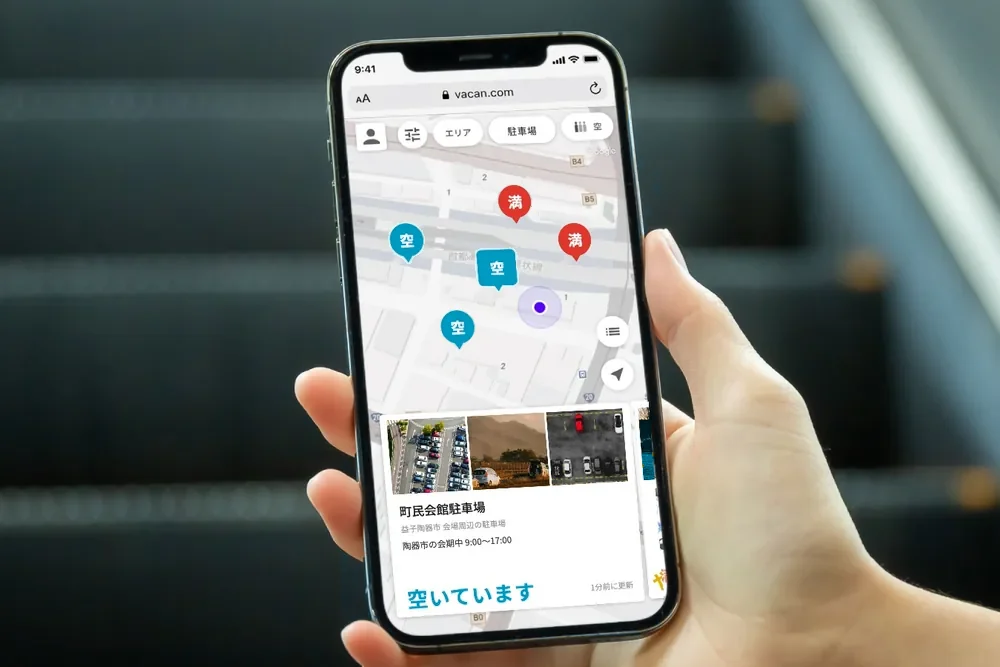 会場周辺の駐車場の混雑を地図とカードで表示する VACAN Maps をスマートフォンで見る手元（益子陶器市）