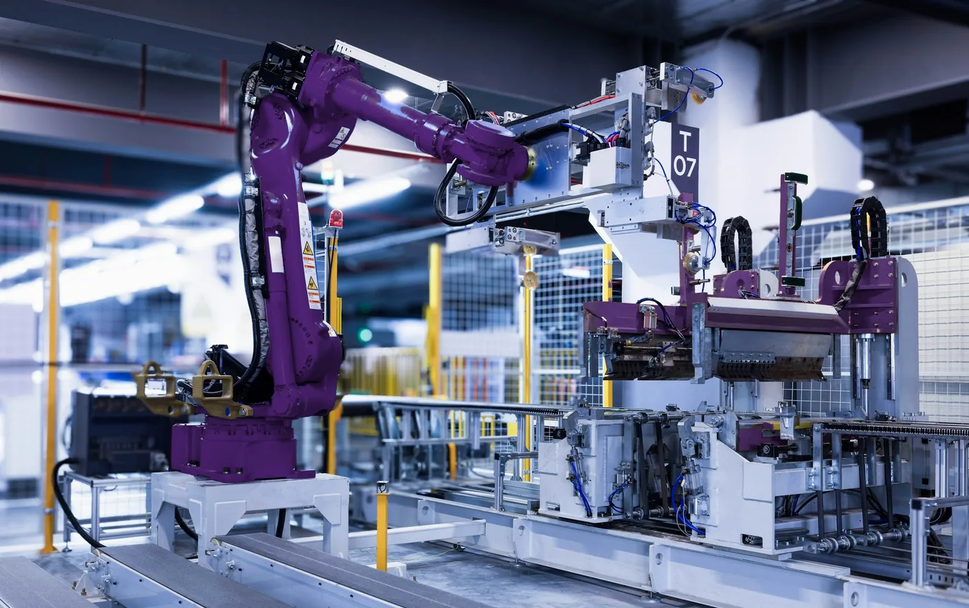 工場の組立ラインで部品を扱う産業用ロボットアーム