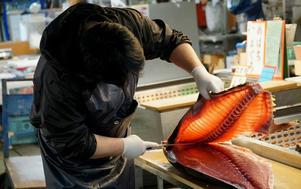 市場で魚をさばく人