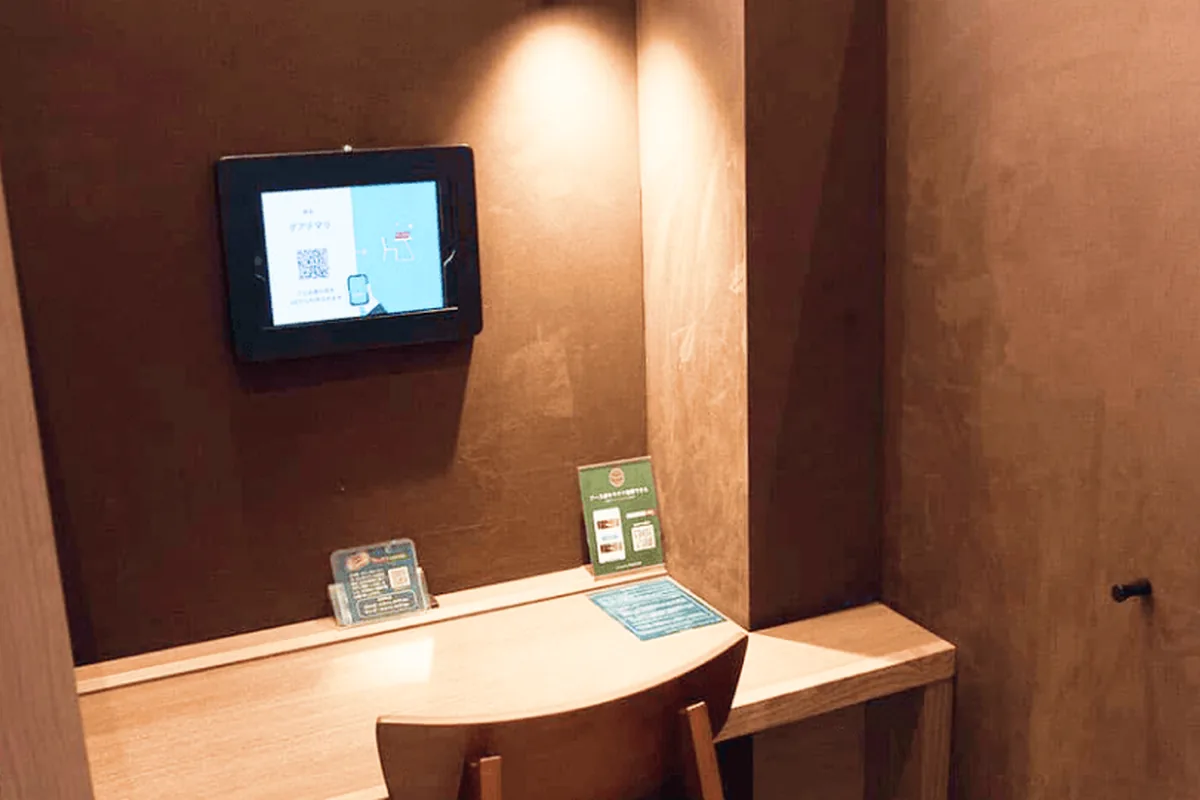 扉付きの 1人用ブース席と、空きを表示するタブレット（タリーズコーヒー）