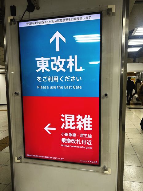 混雑した乗換改札を避けて東改札へ促す柱型サイネージ（JR新宿駅）