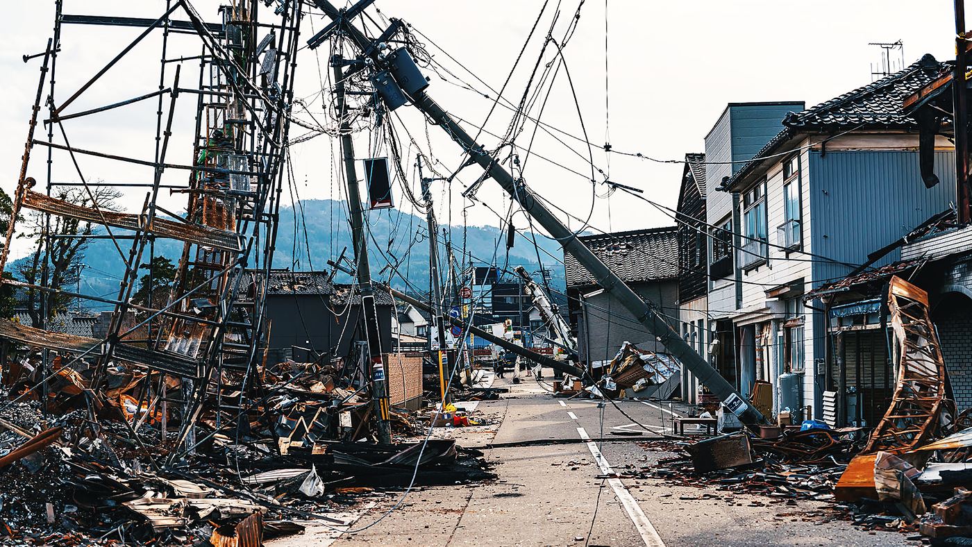 地震で倒壊した電柱と瓦礫が残る市街地