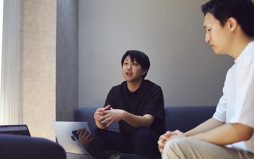 ソファで向かい合って話す2人のメンバー