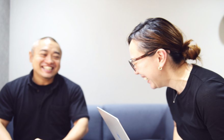 ソファで資料を見ながら話す2人のメンバー