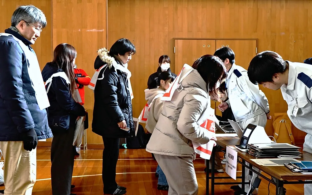 避難所の受付で、職員がタブレットで受け付ける様子