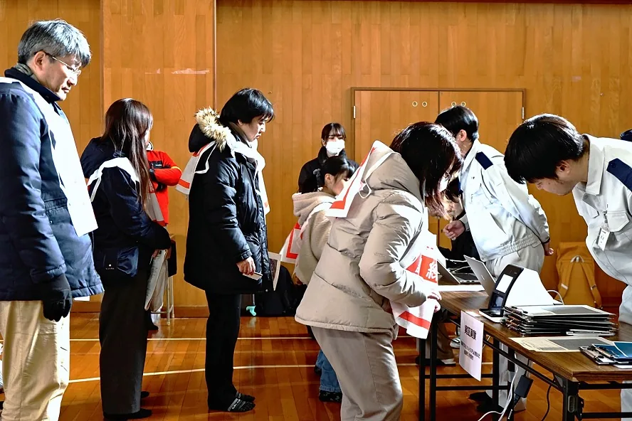 避難所の受付で、職員がタブレットで受け付ける様子